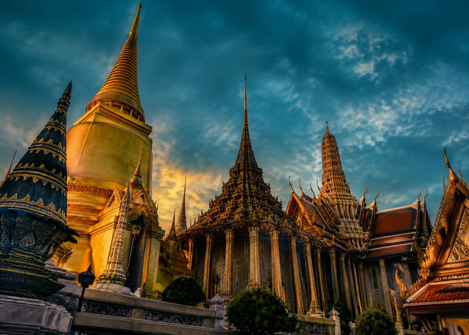 Torres douradas do Grand Palace em Bangkok ao entardecer